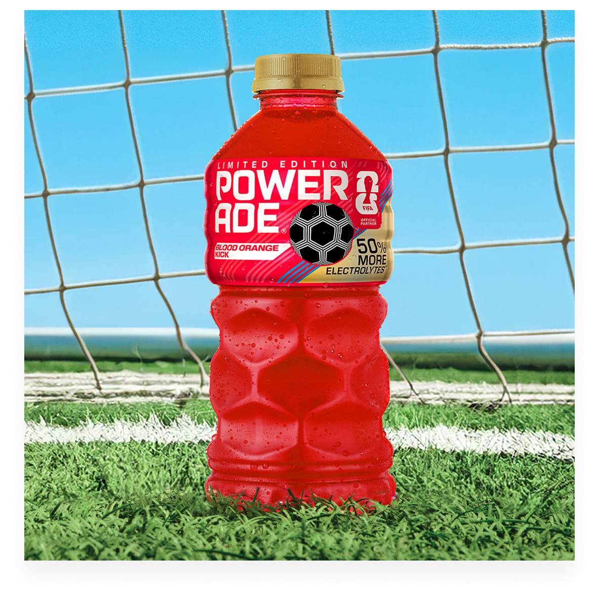 A bottle of Powerade Legacy Powerade Legacy Blood Orange Kick on a soccer field